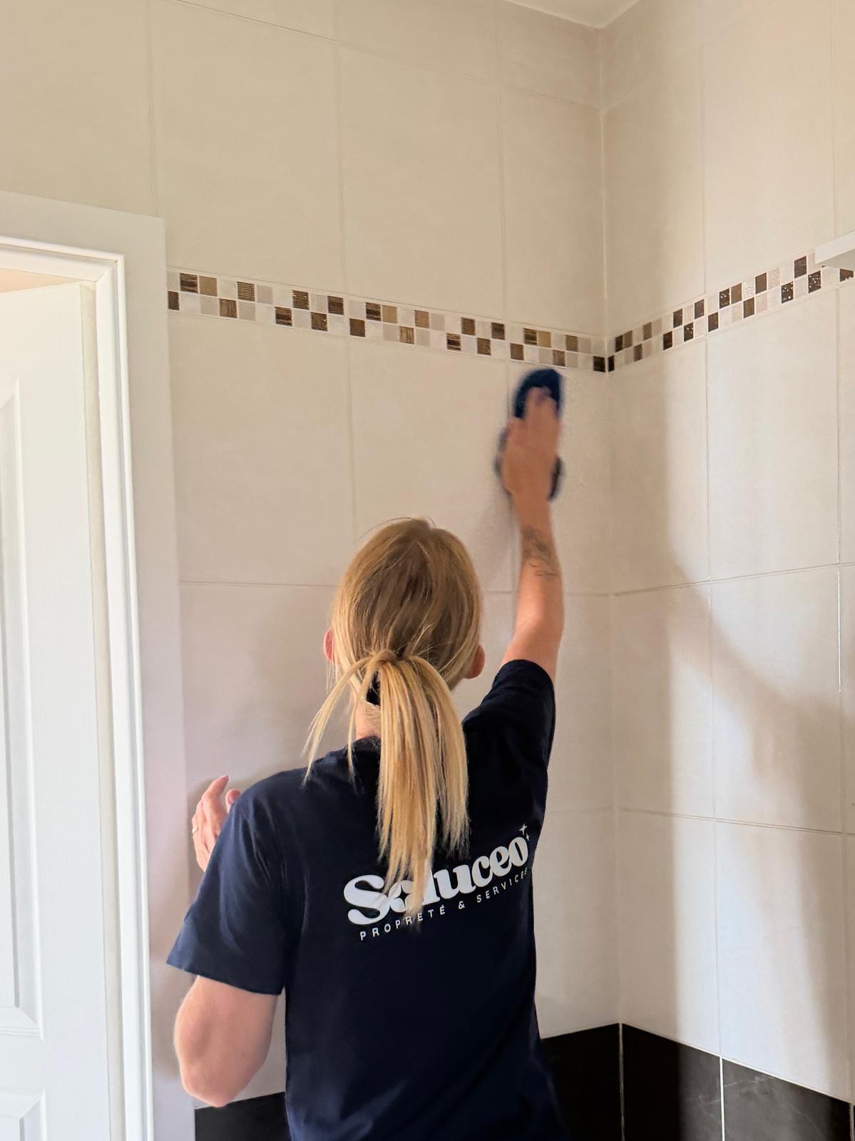 Agent de propreté Soluceo nettoyant une salle d'eau carrelée